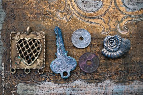 Still Life Photography of symbolic things: a heart, old key, two chinese coins, and a spiral nautilus fossil ammonite. Symbolic objects: relationship, romance, marriage, dreams, travel, or eternity.  photo