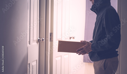 Unrecognize delivery man with box of pardel at the door photo