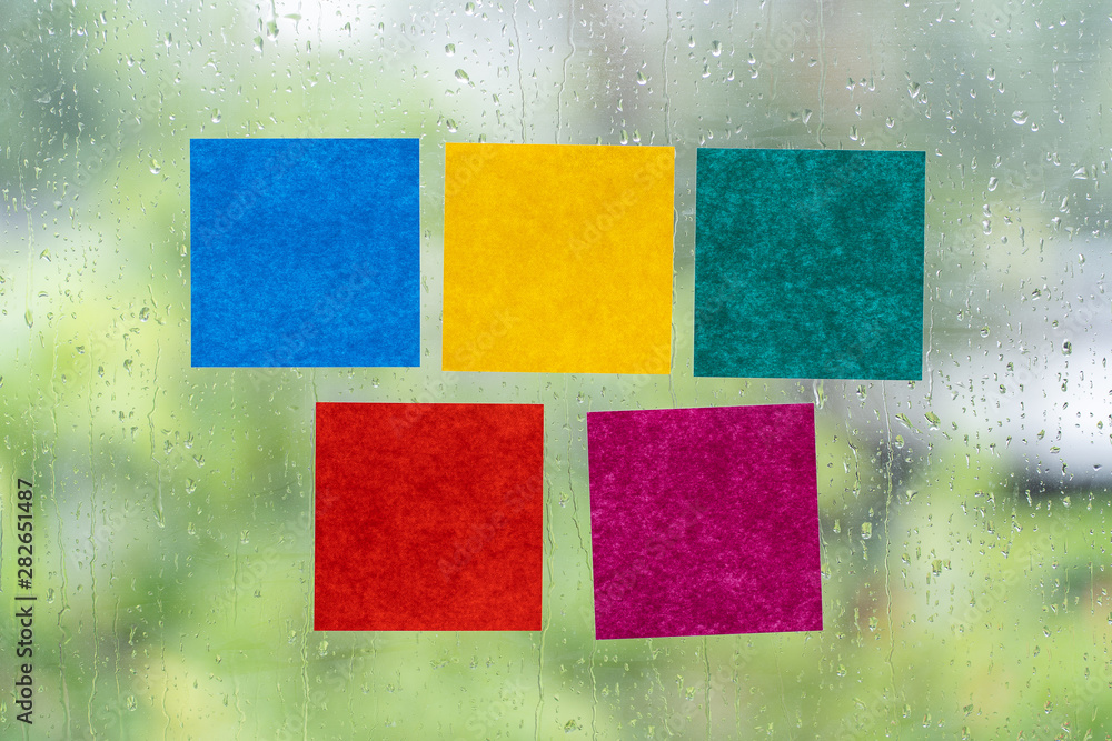 Blank colorful adhesive note stick on windows in raining day