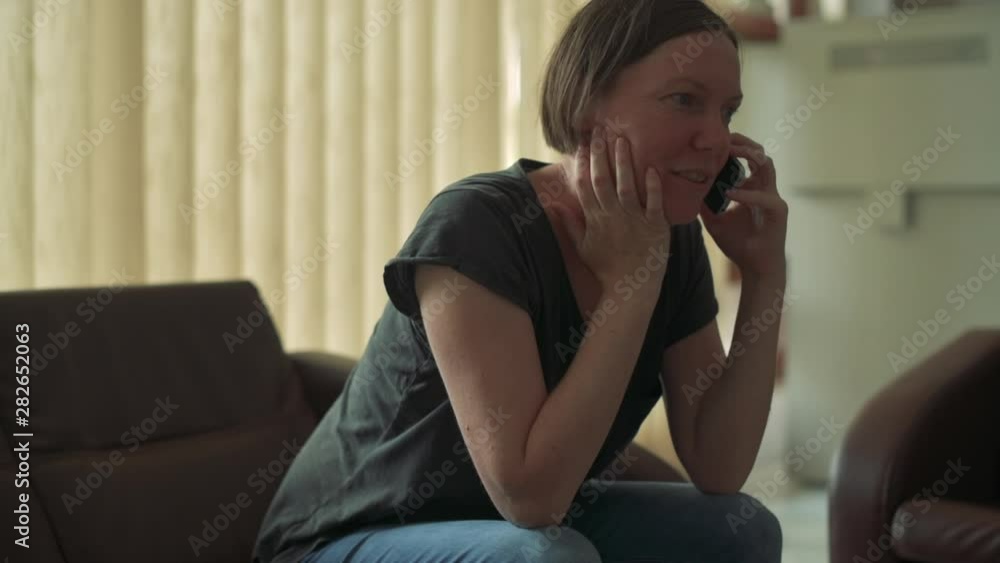Woman during mobile phone conversation in hotel lobby, handheld footage Woman during mobile phone conversation in hotel lobby, handheld footage