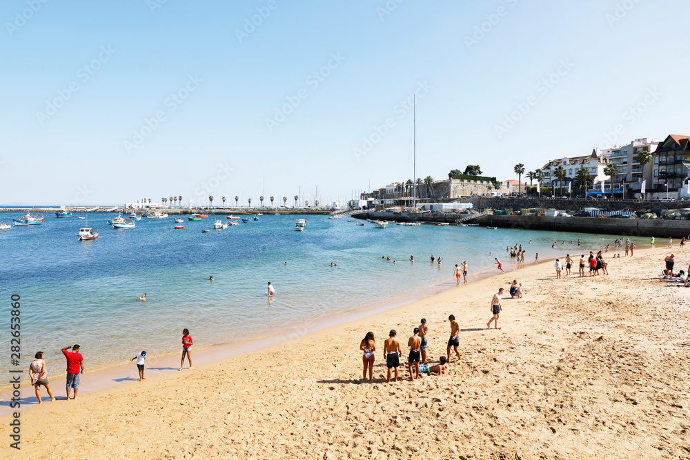 Cascais, Lisbon, Portugal - June 28, 2019: Tourists enjoy Ribeira Beach or Fisherman's Beach, in the center of Cascais, in Lisbon District, in Portugal.