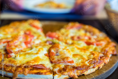 Delicious fresh pizza with tomatoes, salami and melted cheese close