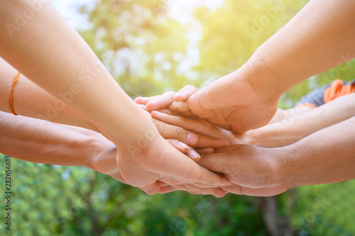 Фотография A group of friends extended their arms to touch their hands for unity