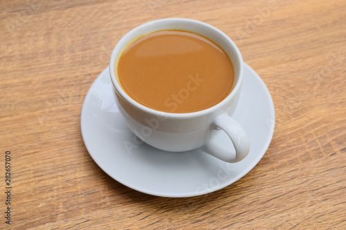  milk coffee in a cup top angle with saucer