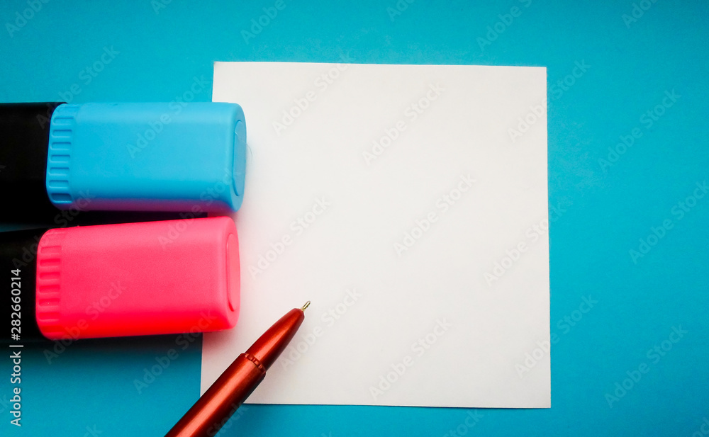 a red pen and two markers, pink and blue on a white sheet of paper. sheet of paper with a red pen. place for text a red pen and two markers, pink and blue on a white sheet of paper. sheet of paper with a red pen. place for text