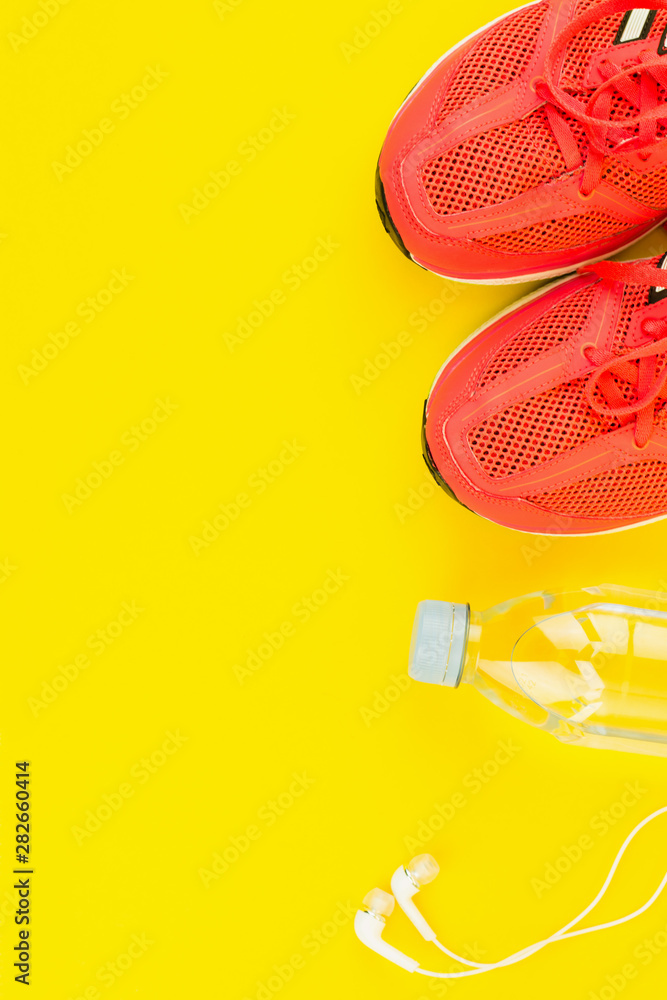 White headphones, a bottle of fresh water and pink sneakers White headphones, a bottle of fresh water and pink sneakers