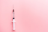 Medical syringe on pink background, health and vaccination concept. Flat lay, mockup, overhead, top view and copy space.