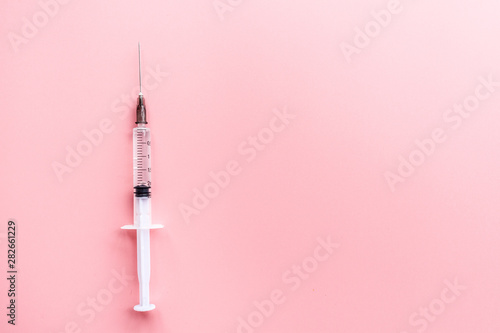 Medical syringe on pink background, health and vaccination concept. Flat lay, mockup, overhead, top view and copy space. photo