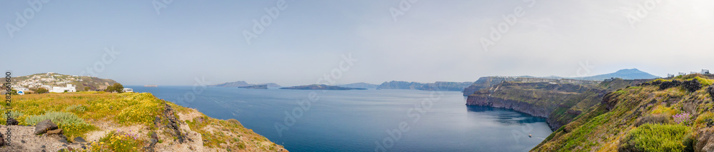Wide view from the bay near the city of Akrotiri, to the inner coastline of the volcanic Thera archipelago and the Nea Kameni island in the center.