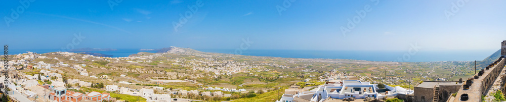 Obraz premium Top north view of the greek Santorini isle, from Pyrgos with aluminium cans for the easter fire festival at the roofs and on the wall of the castle.