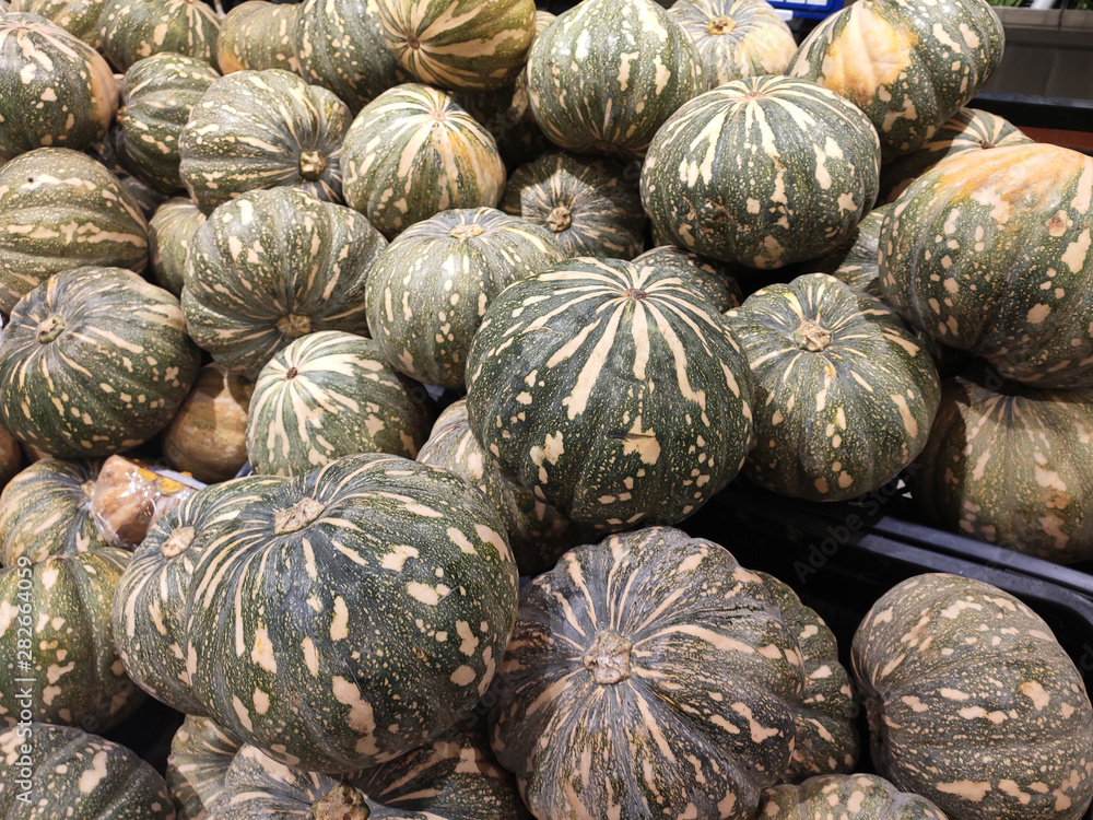 Pile of ripe pumpkin collected and displayed on the rack inside the huge supermarkets for sale. 