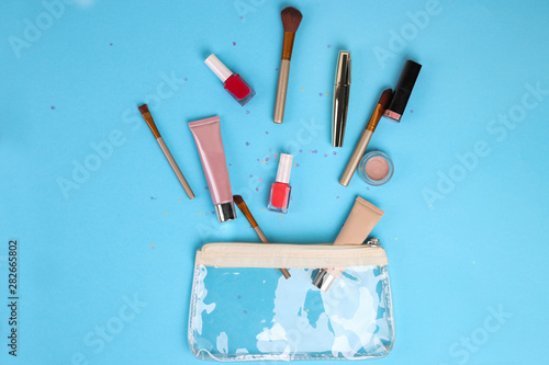 Makeup professional cosmetics on blue background. Top view with copy space.