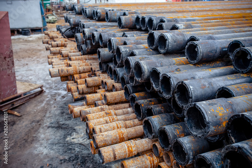 Drill pipe of  oil drilling platforms. Stack of oil well casing bundles at the pin end of casing. Downhole drilling rig