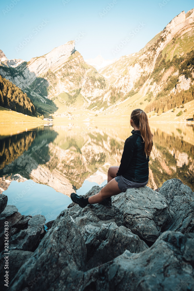 Naklejka premium woman sitting at mountain lake