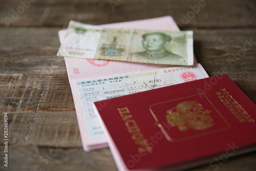 A Russian passport with a Chinese visa and money is one yuan. Visa stamp, passport. Vacation and travel concept.