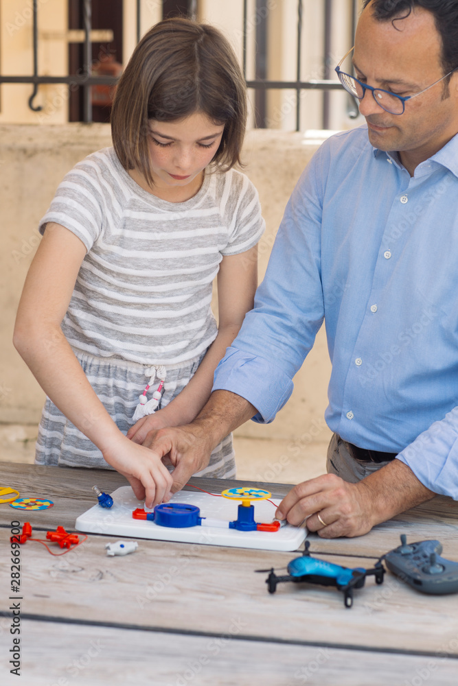 Father teaching his daughter electronics and robotics Father teaching his daughter electronics and robotics