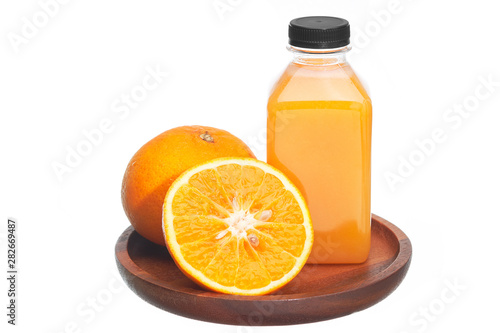 Orange juice in plastic bottles and fruits in wooden plate isolated on white background.
