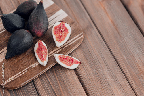 Fototapeta Naklejka Na Ścianę i Meble -  Fresh ripe figs on the brown wooden background.