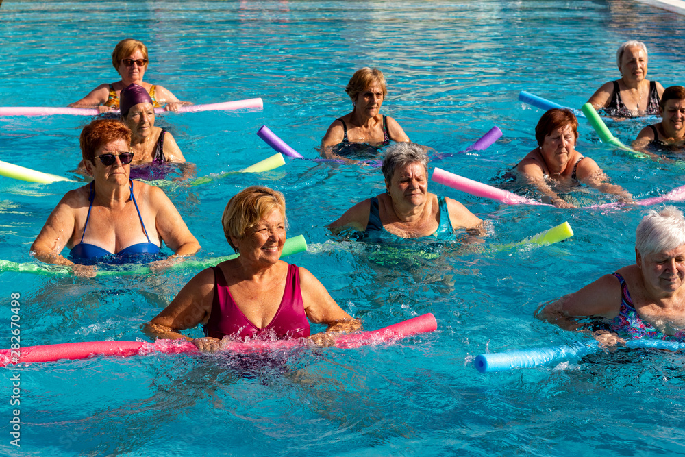 Group of senior ladies doing exercise in outdoor pool. Group of senior ladies doing exercise in outdoor pool.