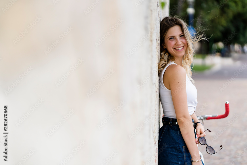 Portrait of happy young woman with sunglasses leaning against wall Portrait of happy young woman with sunglasses leaning against wall