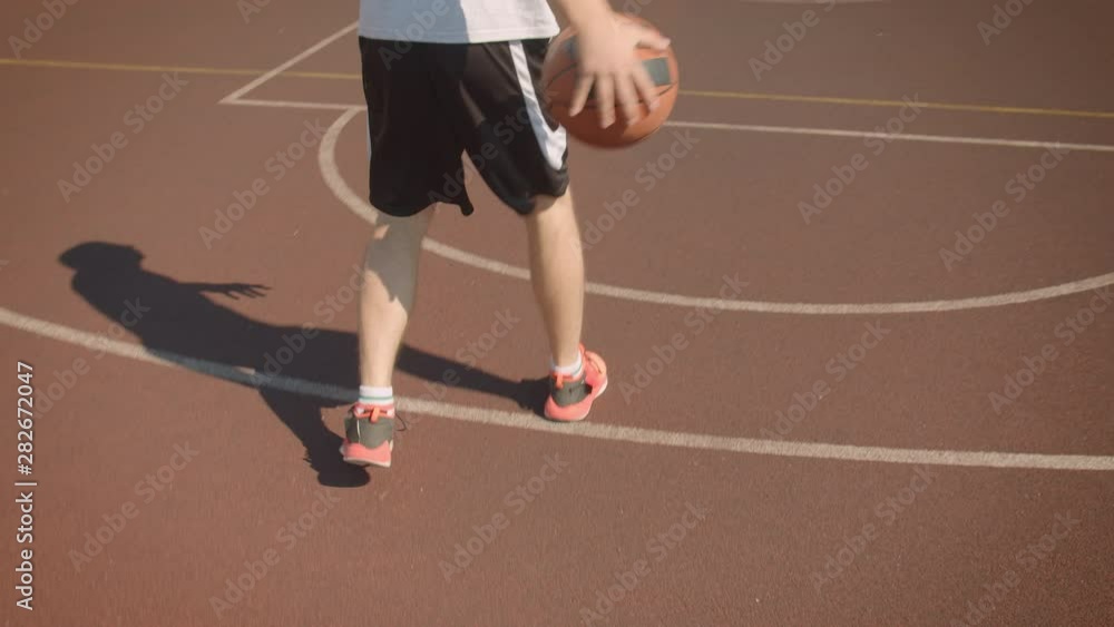 Closeup portrait of young handsome caucasian male basketball player throwing a ball in the hoop on the court outdoors Closeup portrait of young handsome caucasian male basketball player throwing a ball in the hoop on the court outdoors