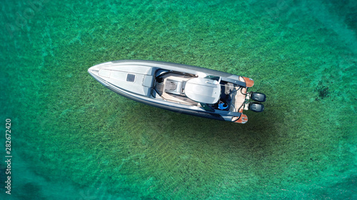 Aerial top view luxury inflatable rib speed boat docked in mediterranean emerald bay with crystal clear sea © aerial-drone