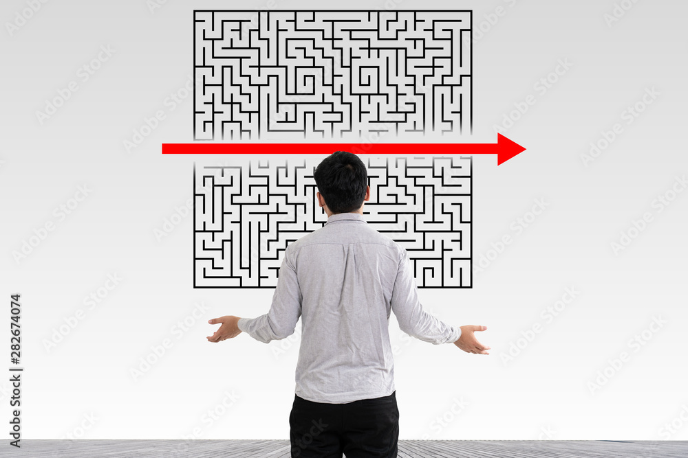 Businessman in doubt looking to a maze and searching the way out Businessman in doubt looking to a maze and searching the way out