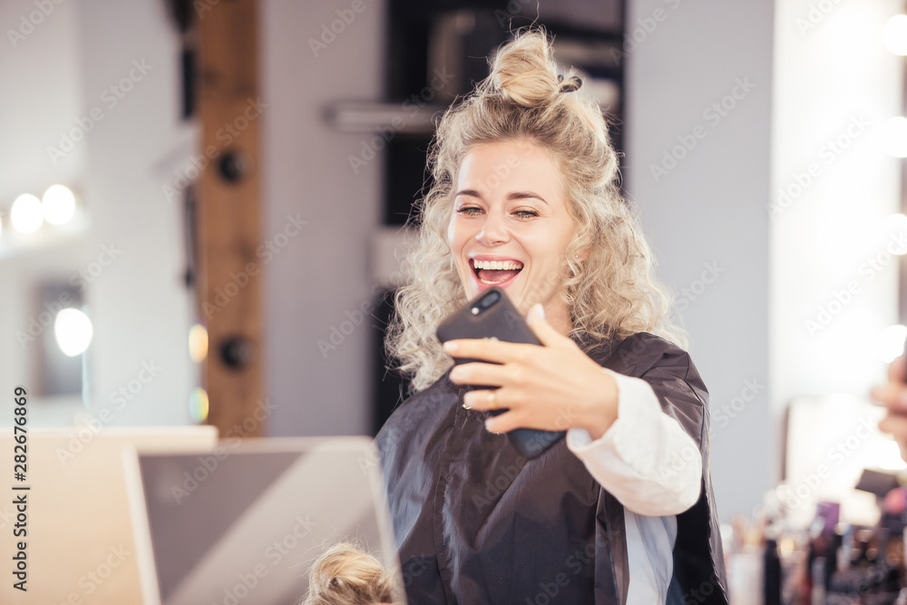 Beautiful young girl model with white hair takes a selfie in a beauty ...