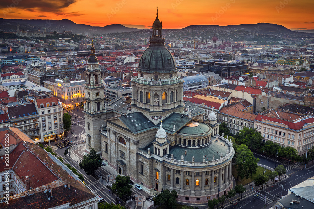 Obraz premium Budapest, Hungary - Aerial drone view of the beautiful St.Stephen's Basilica (Szent Istvan Bazilika) with a golden sunset. Parliament of Hungary and Fisherman's Bastion (Halaszbastya) at background