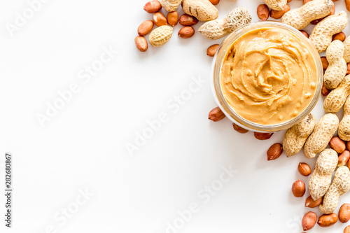 Canvas Print Product for hearty breakfast with peanut butter in bowl near nuts on white backg