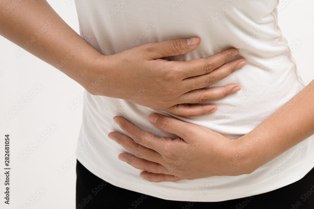Young woman suffering from abdominal pain feeling stomachache, symptom of pms on white background Young woman suffering from abdominal pain feeling stomachache, symptom of pms on white background