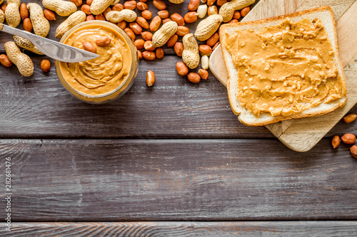 peanut butter for cooking breakfast with sandwiches at home on wooden background top view mock-up