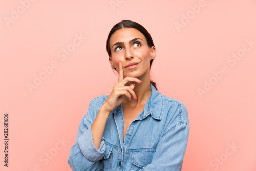 Obraz na plátně Young woman over isolated pink background thinking an idea