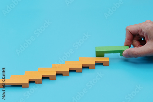 Business concept for growth success process, hand stacking wood block as step stair