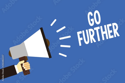 Handwriting text writing Go Further. Concept meaning To move to a greater distance or overcome your limitations Man holding megaphone loudspeaker blue background message speaking loud photo