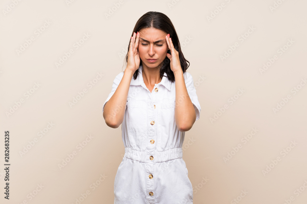 Young woman over isolated background with headache Young woman over isolated background with headache