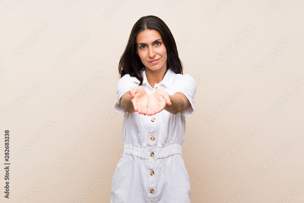 Young woman over isolated background holding copyspace imaginary on the palm to insert an ad Young woman over isolated background holding copyspace imaginary on the palm to insert an ad