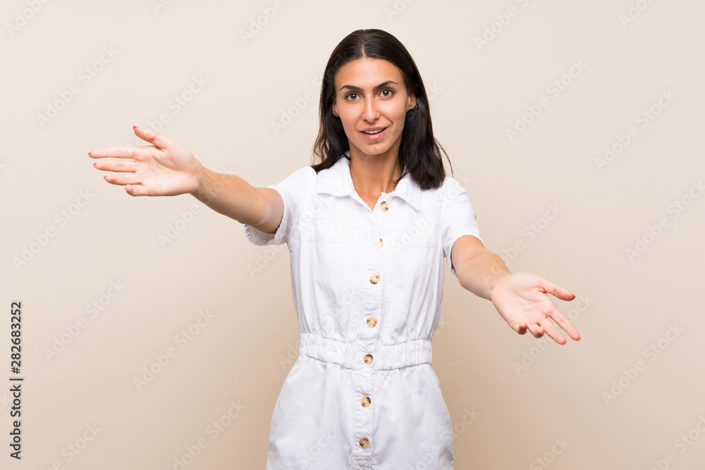 Young woman over isolated background presenting and inviting to come with hand Young woman over isolated background presenting and inviting to come with hand