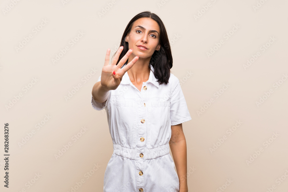 Young woman over isolated background happy and counting four with fingers Young woman over isolated background happy and counting four with fingers