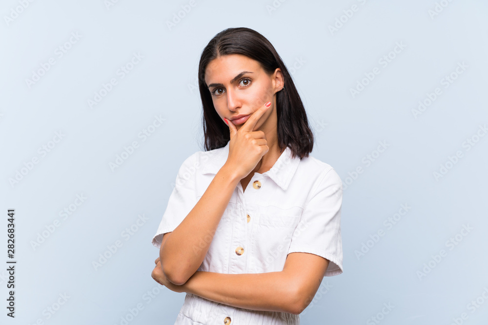 Young woman over isolated blue background thinking an idea Young woman over isolated blue background thinking an idea