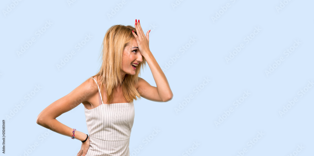 Young blonde woman has realized something and intending the solution over isolated blue background