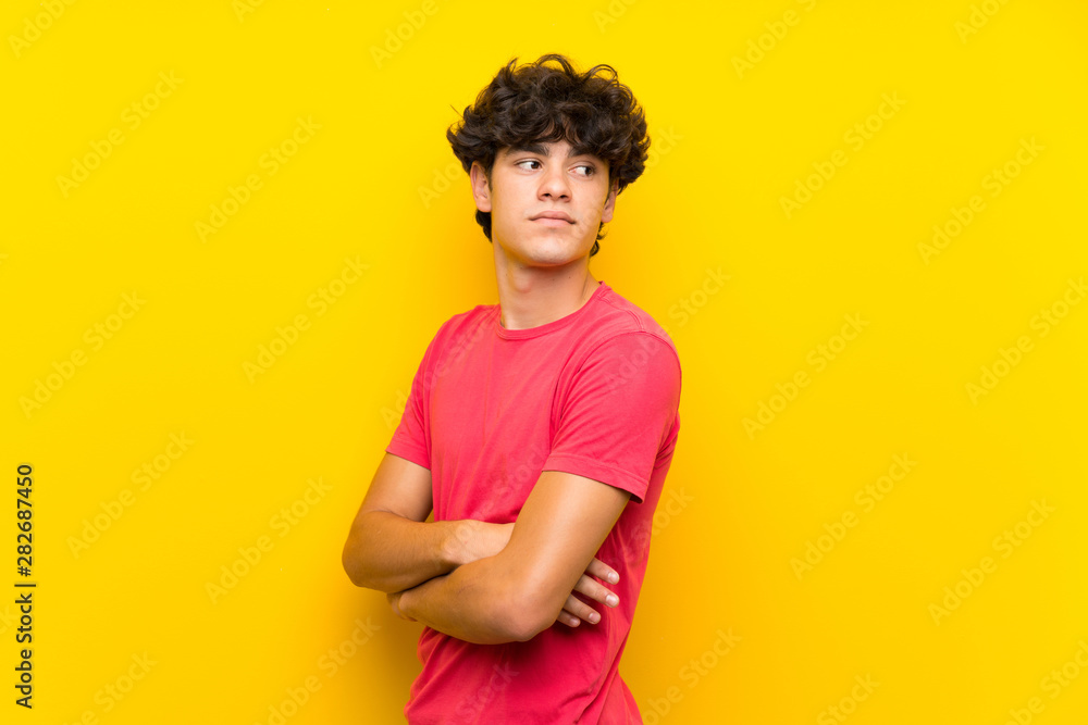Young man over isolated yellow wall laughing Young man over isolated yellow wall laughing