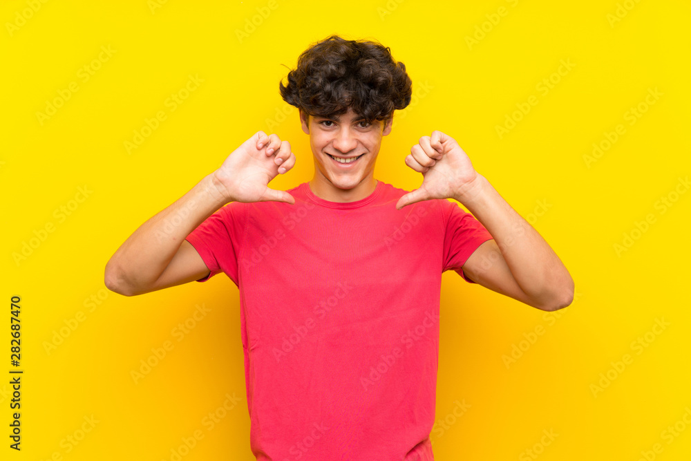 Young man over isolated yellow wall proud and self-satisfied Young man over isolated yellow wall proud and self-satisfied