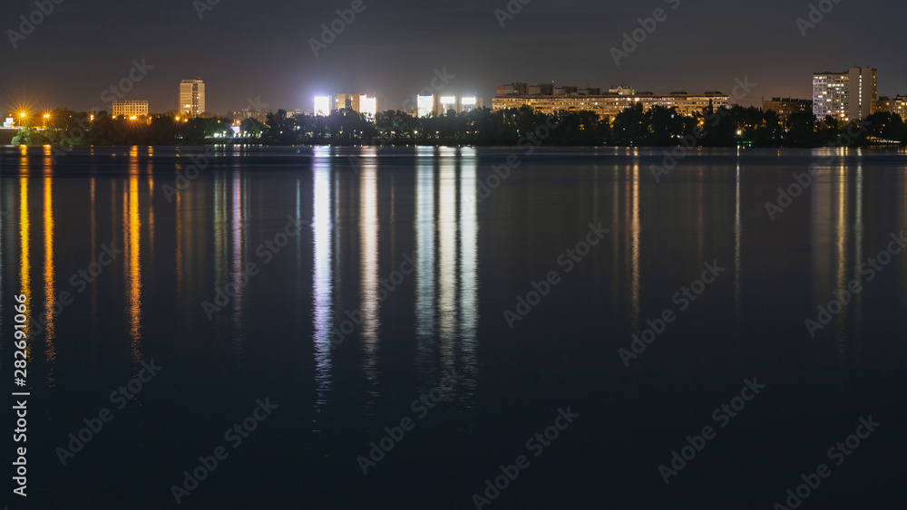 Skyline panorama of night city with lights reflection over water