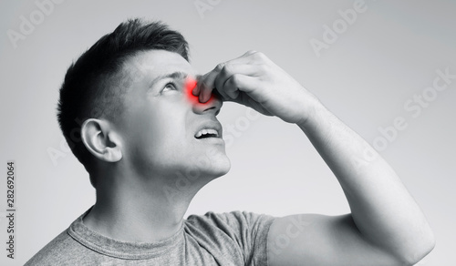 Konstfotografi Young man suffering from nose bleeding, black and white