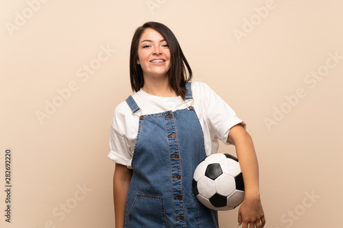 Young Mexican woman over isolated background holding a soccer ball © luismolinero