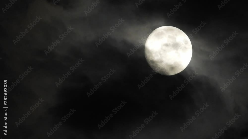 Moon With Clouds In The Night Sky. Concept of a spooky theme and mystery. Mysterious night sky with moon and dramatic clouds passing. Dark night with moon. Moon With Clouds In The Night Sky. Concept of a spooky theme and mystery. Mysterious night sky with moon and dramatic clouds passing. Dark night with moon.
