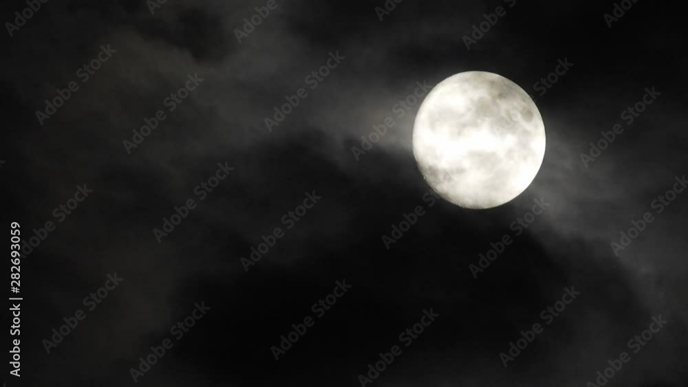 Moon With Clouds In The Night Sky. Concept of a spooky theme and mystery. Mysterious night sky with moon and dramatic clouds passing. Dark night with moon. Moon With Clouds In The Night Sky. Concept of a spooky theme and mystery. Mysterious night sky with moon and dramatic clouds passing. Dark night with moon.