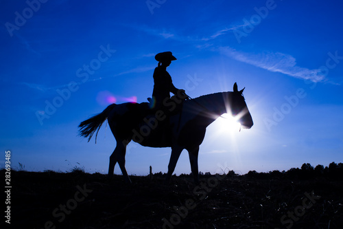 Silhouette cowgirl on horse at sunset in blue (12)
