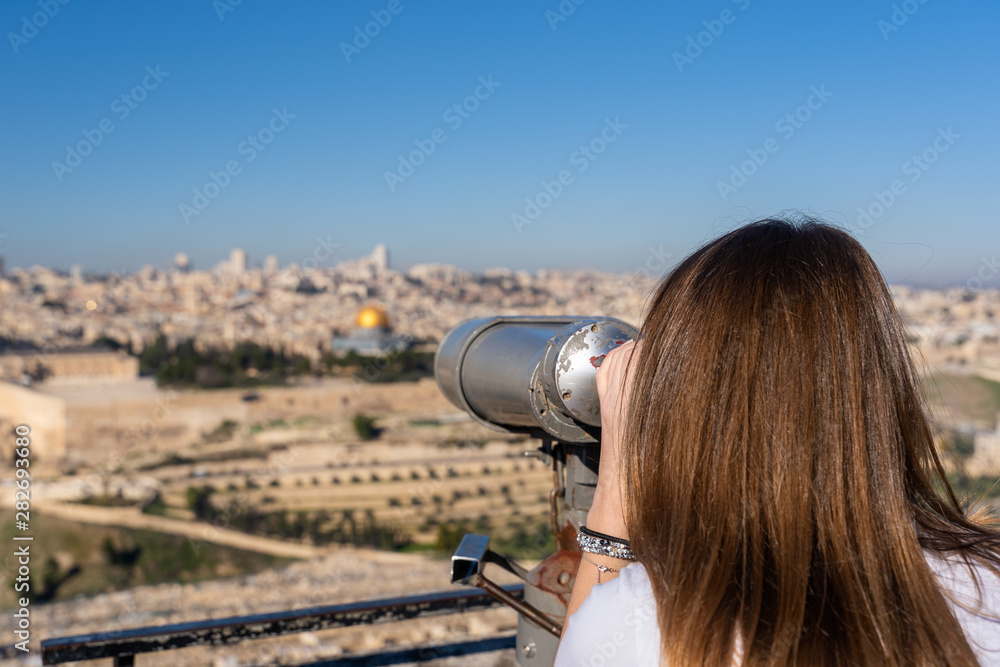 Woman watching the Old City of Jerusalem with a binocular